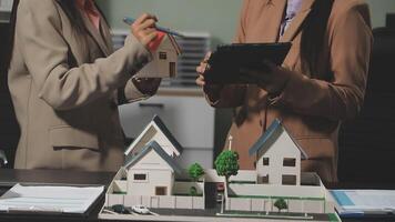 Two business people looking at a model of a house video