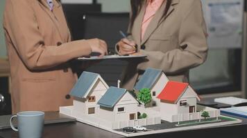 Two women are looking at a model of a house video