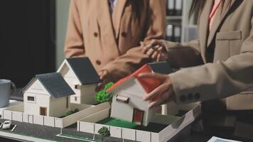 Two people are looking at a model of a house video