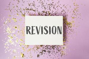 Revision is a word written on a white background with gold glitter photo