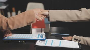 Two people shaking hands over a desk with papers video