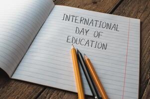 A notebook with pencils on it and the words International Day of Education photo