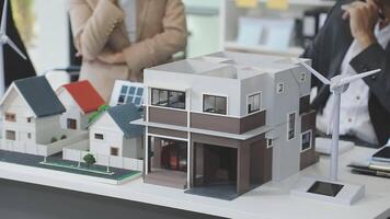 A model of a house with people standing around it video