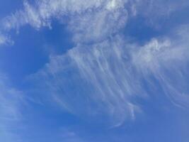 The sky is blue and clear with a few clouds scattered throughout photo