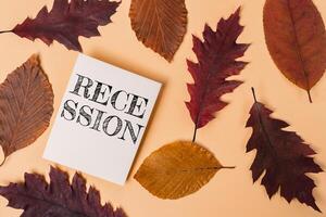 White piece of paper with the word recession written on it is placed on top of photo