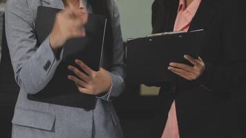 Two businesswomen are holding a clipboard and pointing at something video
