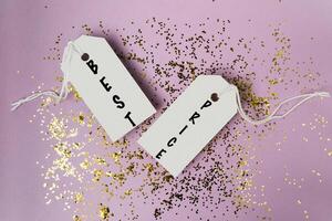Two tags with the word best on them are hanging from a string photo
