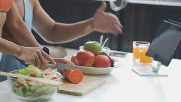 A man and woman cutting vegetables and fruit on a table video