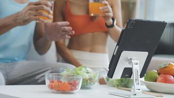 A man and woman sitting at a table with a tablet and a glass of juice video