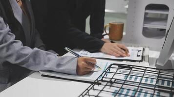 Two people working on a computer with a pen and paper video