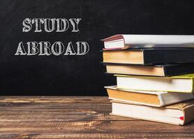 A stack of books with the word study abroad written on top photo