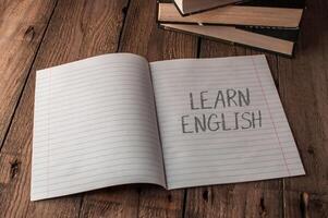 A notebook is open to a page with the word learn english written on it photo