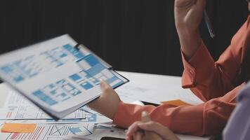 Two people sitting at a table with a laptop and papers video