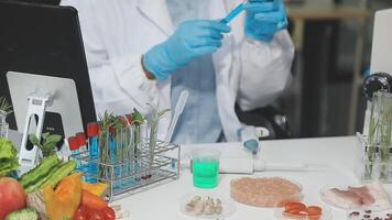 A man in a lab coat is working on a computer video