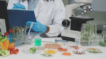 A woman in a lab coat is looking at a clipboard video