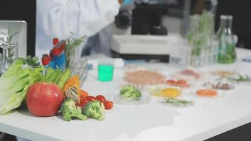 A man in a lab coat is working on a table with various vegetables and fruits video