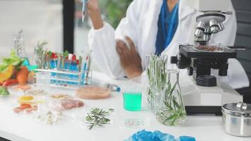 A woman in lab coat is looking at a microscope video