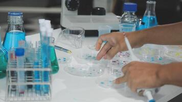 A person is working in a laboratory with blue and white liquid video