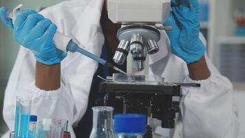 A person in a lab coat is looking at a microscope video