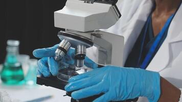 A person in a lab coat is looking at a microscope video