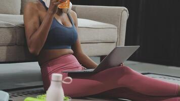 A woman sitting on the floor with a laptop and orange juice video