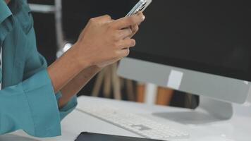 A woman is using her cell phone while sitting at a desk video