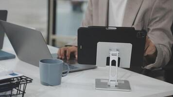A person is using a laptop and tablet on a desk video