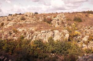 fantastic autumn in a mountain canyon, huge rocks. Mountains of large granite boulders, stone ledges for mountaineering and walking. trees and meadows grow among the rocks. Aktovsky Canyon, Ukraine. photo