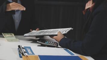 Two business people sitting at a table with paperwork video