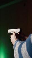 Vertical Man in shooting gallery using firearm, looking at results on moving target. Close up of person training for competitive shooting sport, sharpening skills, checking points scored on bullseye, camera A video