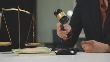 A judge holding a gavel and money on a desk video
