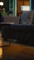vertical elegante vacío Departamento desván con un cómodo sofá y inteligente televisión en el vivo habitación, moderno espacio con decoraciones y miedoso neón luces. estudio con un café mesa y hogar teatro configuración. video