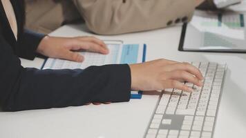 A person typing on a keyboard and a paper video