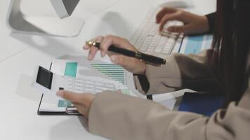 A person is using a calculator and pen on a desk video
