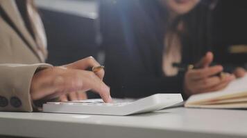 Two business people using a calculator at a desk video