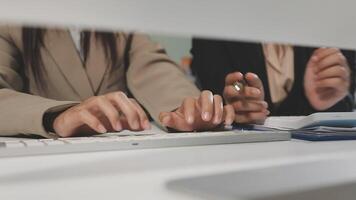Two people in business attire typing on a keyboard video