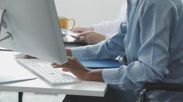A person sitting at a desk with a computer and a phone video