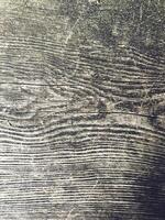 The image is a close up of a wooden surface with a grainy texture photo