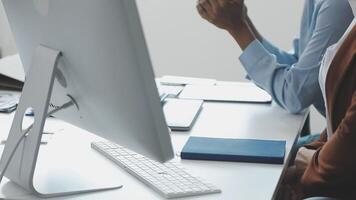 Two people sitting at a desk with a computer video
