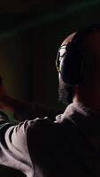 Vertical Shooting gallery customer using pistol to hit targets, wearing protection headset. Person wearing safety earmuffs at firing range shooting bullseyes, enjoying using weapon video