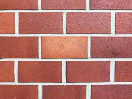 Brick wall with a red brick in the middle photo
