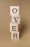 Stack of wooden blocks with the word over written on them photo