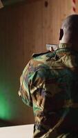 Vertical Man in firing range shooting targets with pistol doing celebratory hand gesture after being successful. African american soldier cheering after managing to accurately hit bullseye, camera A video