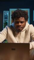 vertical focado homem acionado dentro conectados pesquisa para uma trabalhos projeto às lar, sentado às dele café mesa com computador portátil e lendo artigos em a Internet. pessoa surfar paginas web e encontro dados. Câmera b. video