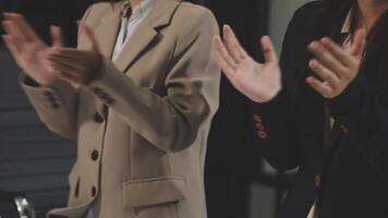 Two businesswomen clapping in front of a computer video