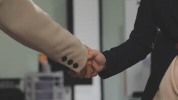 Two people shaking hands in an office video