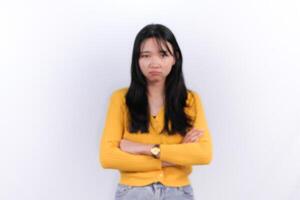 a woman in a yellow sweater standing with her arms crossed photo