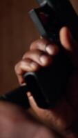 Vertical Man holding pistol enjoying recreational indoor shooting experience in firing range facility, close up. Person practicing with handgun in safe environment at shooting range company, camera A video