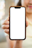 A person holds a smartphone with a blank screen, perfect for mockups or design presentations in a bright indoor environment. photo