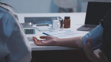 A doctor is holding a patient's hand while sitting at a desk video